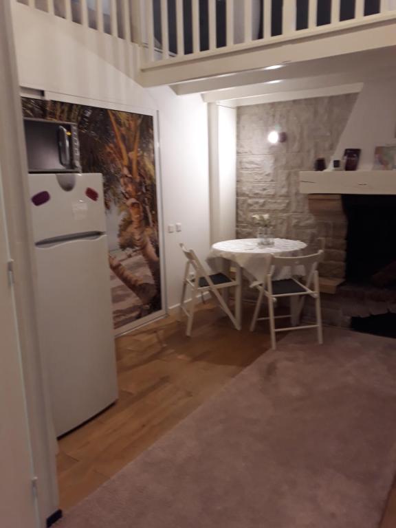 a kitchen with a white refrigerator and a table at STUDIO INDEPENDENT in Margaux