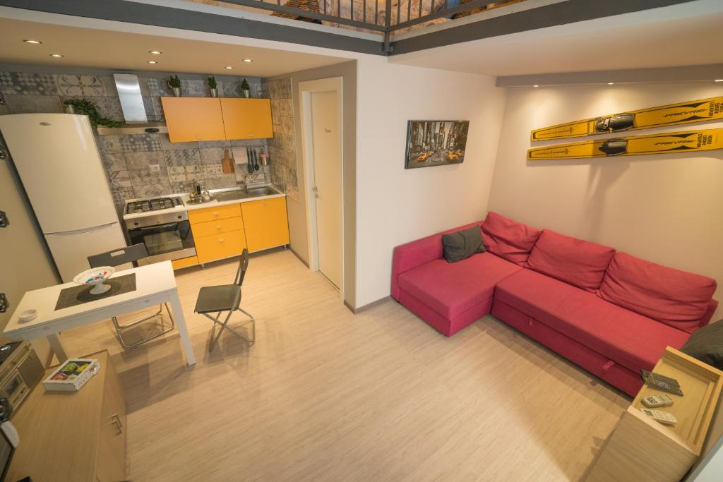 un soggiorno con divano rosso e una cucina di Central Station House Daniele a Catania
