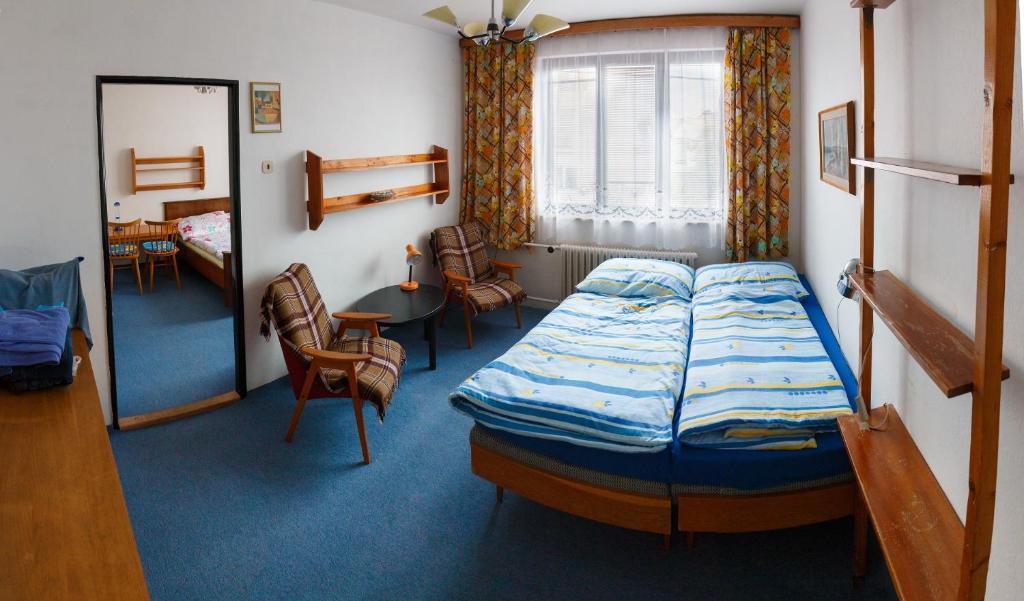 Family House Moravsky Kras في Vilémovice: غرفة نوم بسرير وطاولة وكراسي