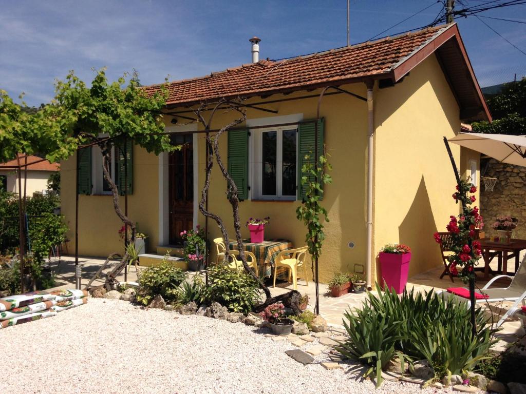 a small house with a patio and a table at Le 43 in La Trinité