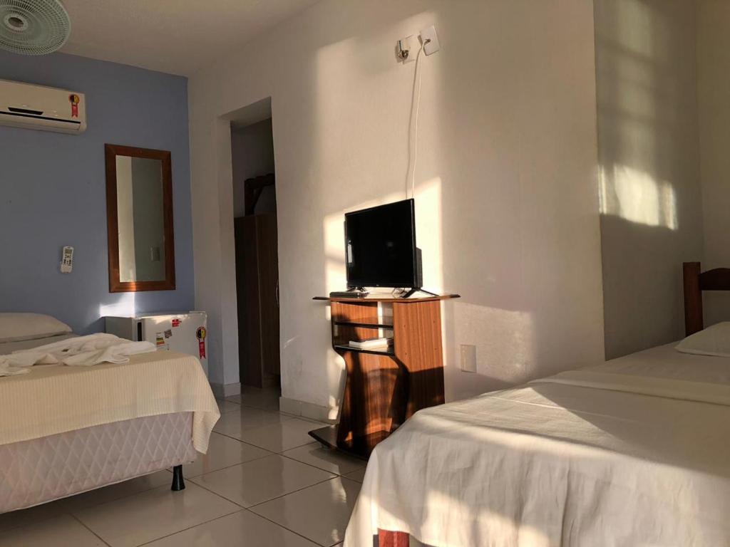 Uma cama ou camas num quarto em Pousada Caravelas