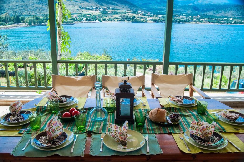 una mesa con comida y vistas al agua en Aphrodite's Coast Retreat House!, en Galaxidhion