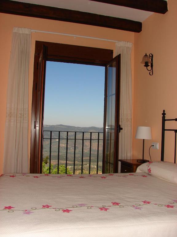 Un dormitorio con una gran ventana con vistas. en Apartamentos Sierra de Segura, en Segura de la Sierra