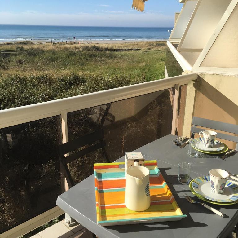 une table sur un balcon avec vue sur la plage dans l'établissement Vistamar 2, à Merlimont