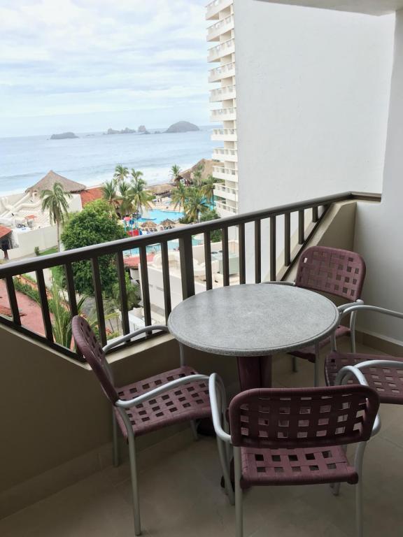 einen Balkon mit einem Tisch und Stühlen sowie Strandblick in der Unterkunft Departamento 522 con playa dentro de Hotel en Ixtapa in Ixtapa