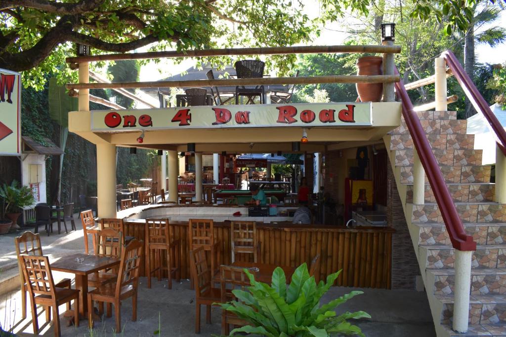 a one day road restaurant with wooden tables and chairs at One 4 Da Road in Panglao