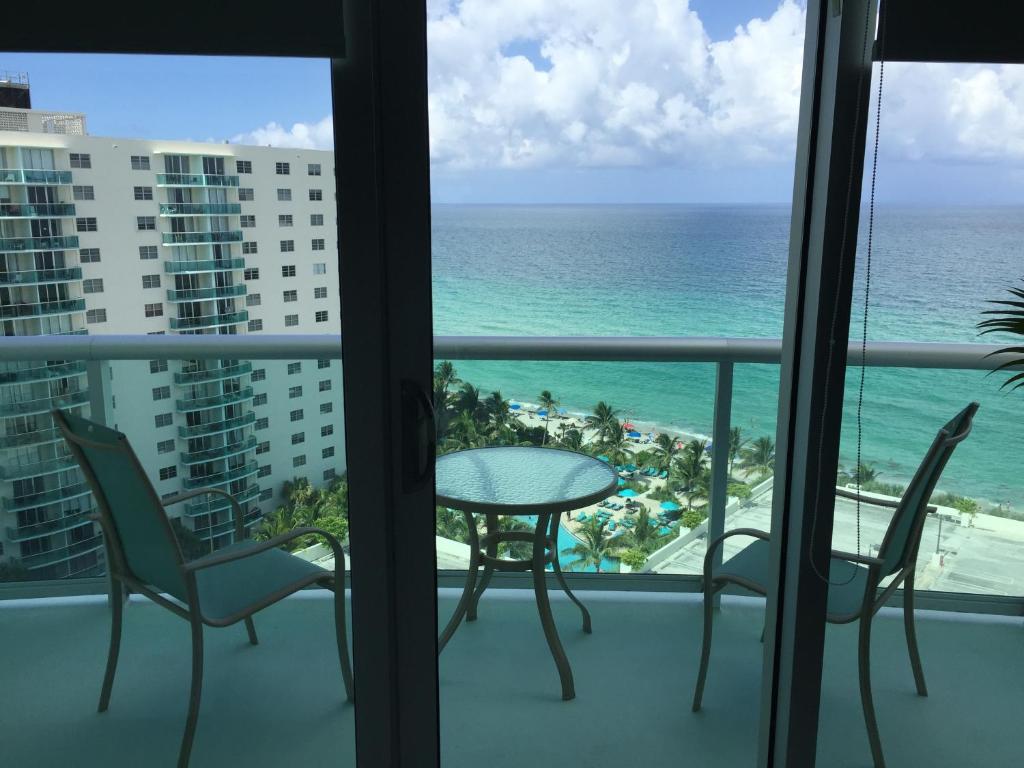 a balcony with a table and chairs and the ocean at Hollywood on Beach Apartment in Hollywood