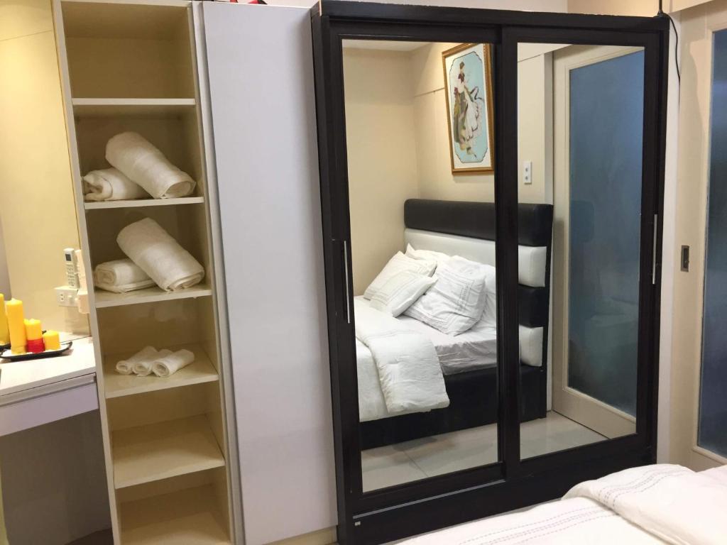 a mirror in a room with a bed and towels at Deluxe residence in Manila