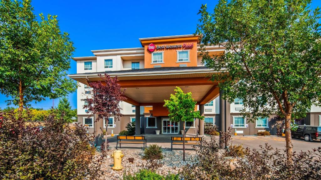 a hotel building with benches in front of it at Best Western Plus Estevan Inn & Suites in Estevan