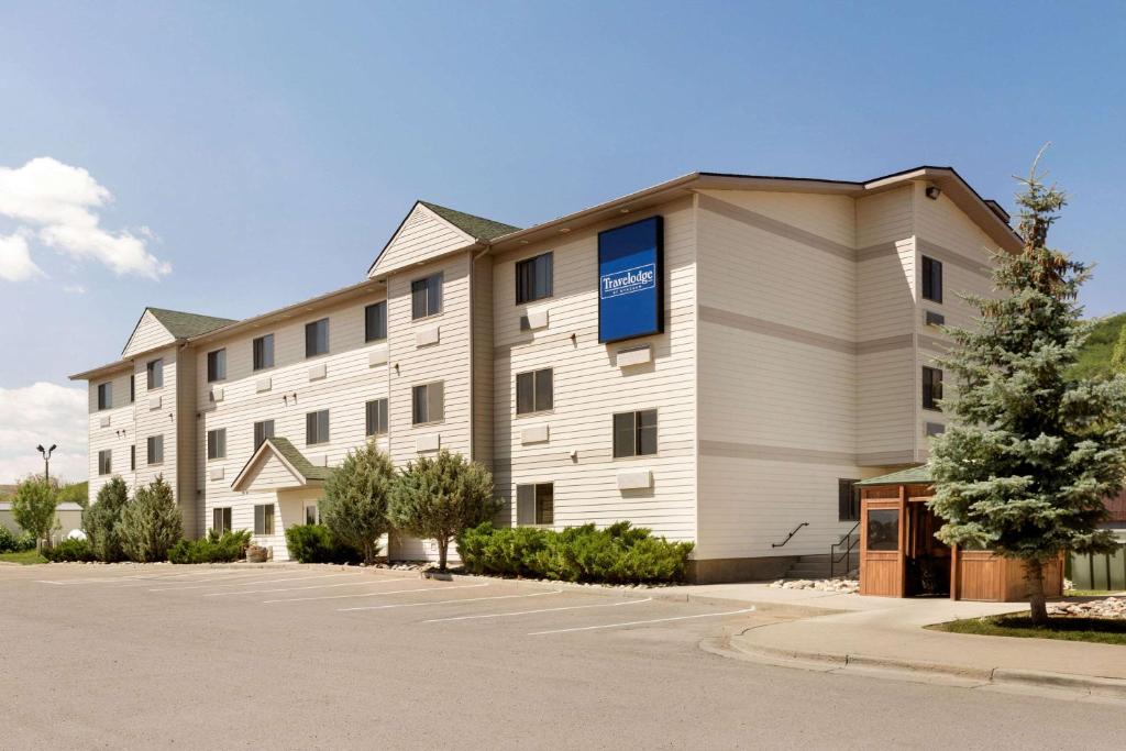 a large white building with a blue sign on it at Travelodge by Wyndham Yampa in Yampa