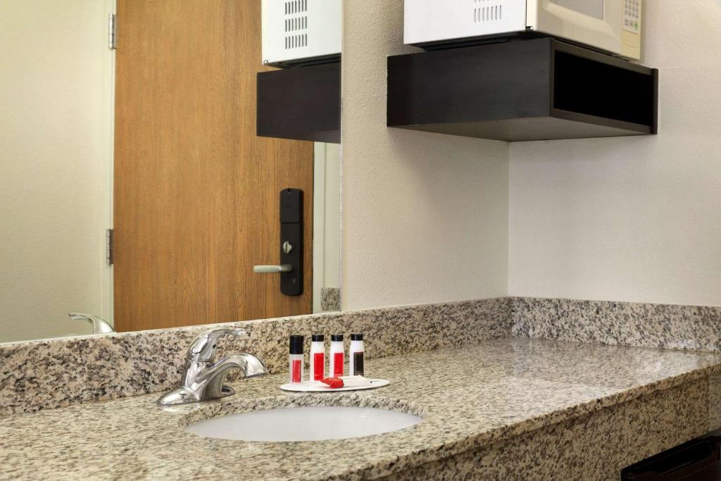 a bathroom counter with a sink and a mirror at Travelodge by Wyndham Yampa in Yampa