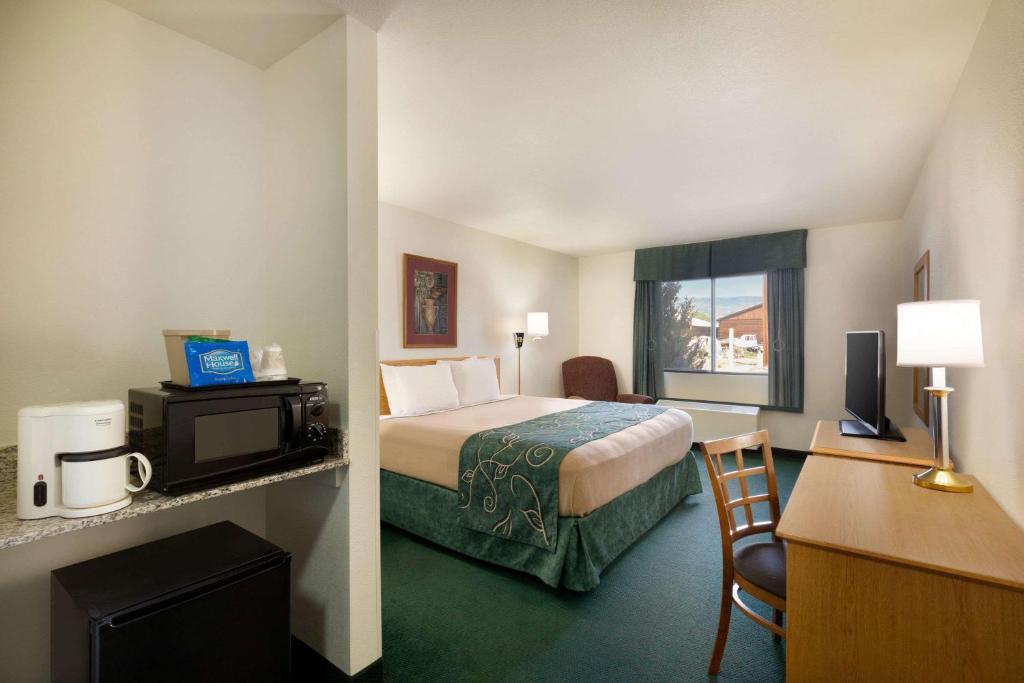 a small hotel room with a bed and a desk at Travelodge by Wyndham Yampa in Yampa