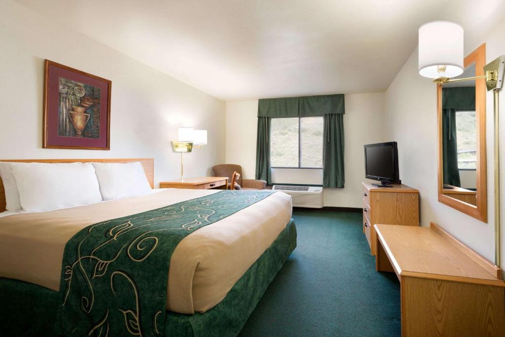 a hotel room with a large bed and a television at Travelodge by Wyndham Yampa in Yampa