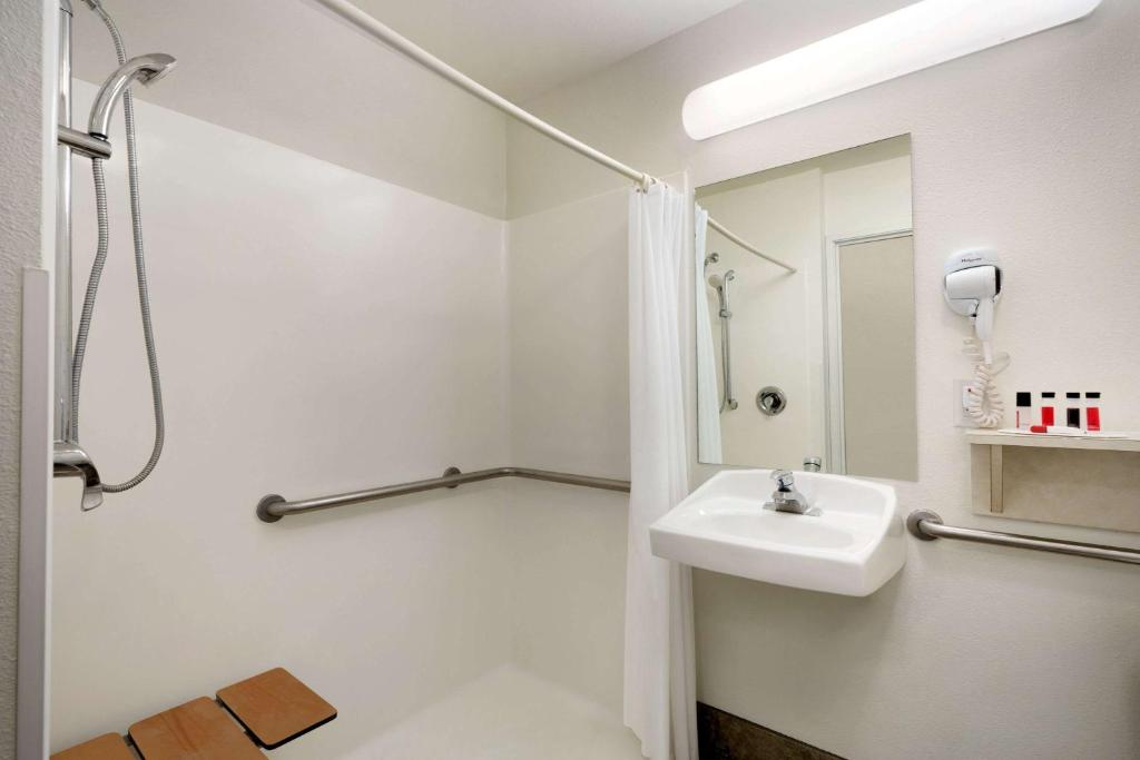 a white bathroom with a sink and a mirror at Travelodge by Wyndham Yampa in Yampa