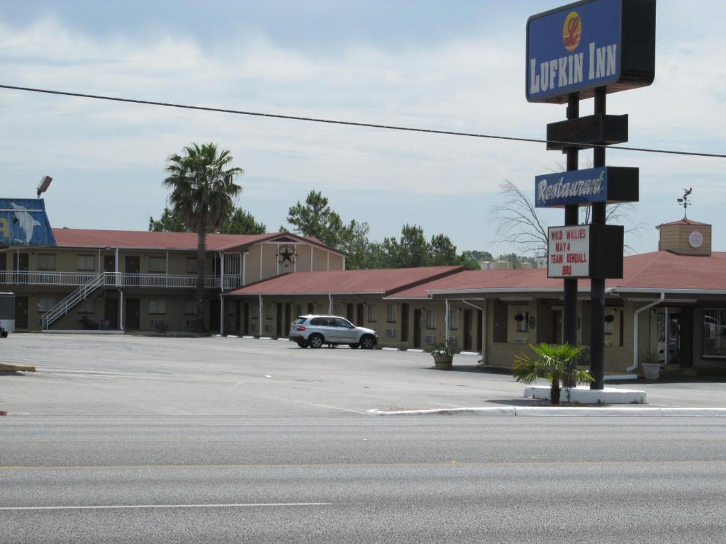 un estacionamiento vacío en una pequeña ciudad con un letrero de calle en Lufkin Inn, en Lufkin