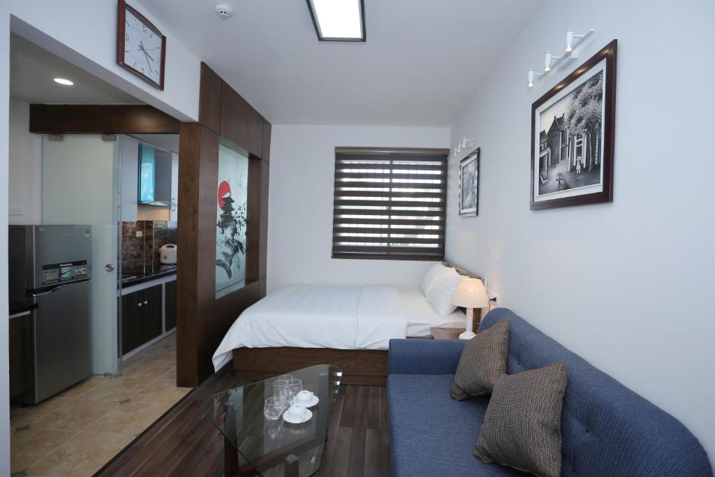 a living room with a bed and a blue couch at Cat Linh ARL55 Hotel in Hanoi