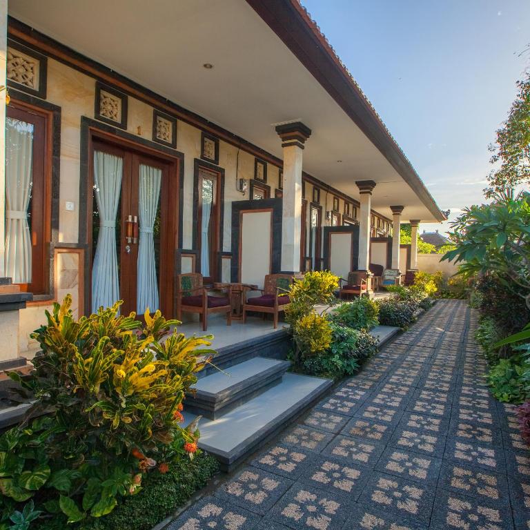 a house with a walkway leading to the front porch at Taman Bali Homestay Sanur in Sanur