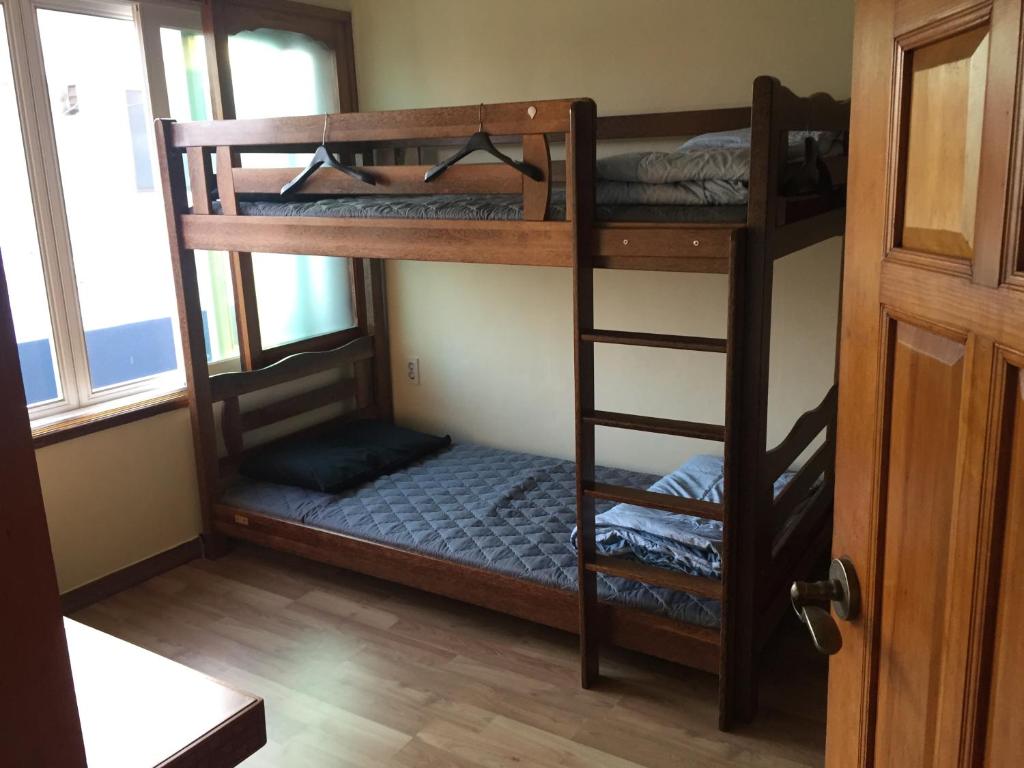 Ένα ή περισσότερα κρεβάτια σε δωμάτιο στο Jeju Guesthouse