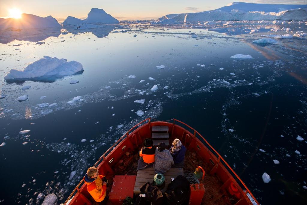 a group of people sitting on a boat in the water at Hotel Icefiord in Ilulissat