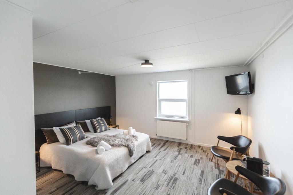 a bedroom with a bed and a tv on a wall at Hotel Icefiord in Ilulissat