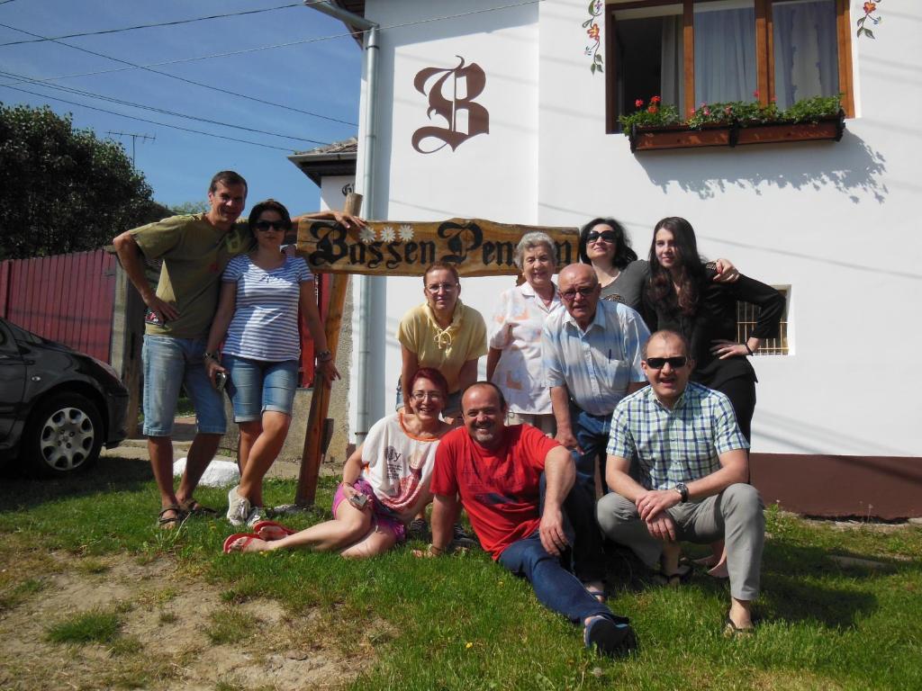 a group of people posing for a picture in front of a house at Pension Bassen in Bazna