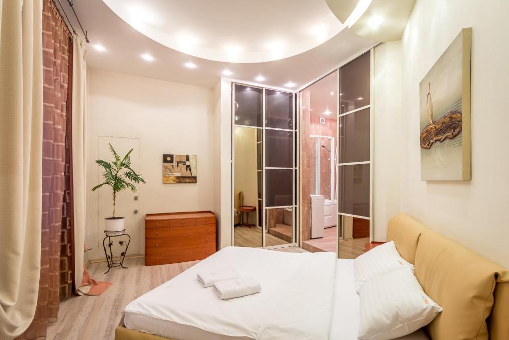 キーウにあるDayFlat Apartments Khreschatykの白いベッドとレンガの壁が備わるベッドルーム1室が備わります。