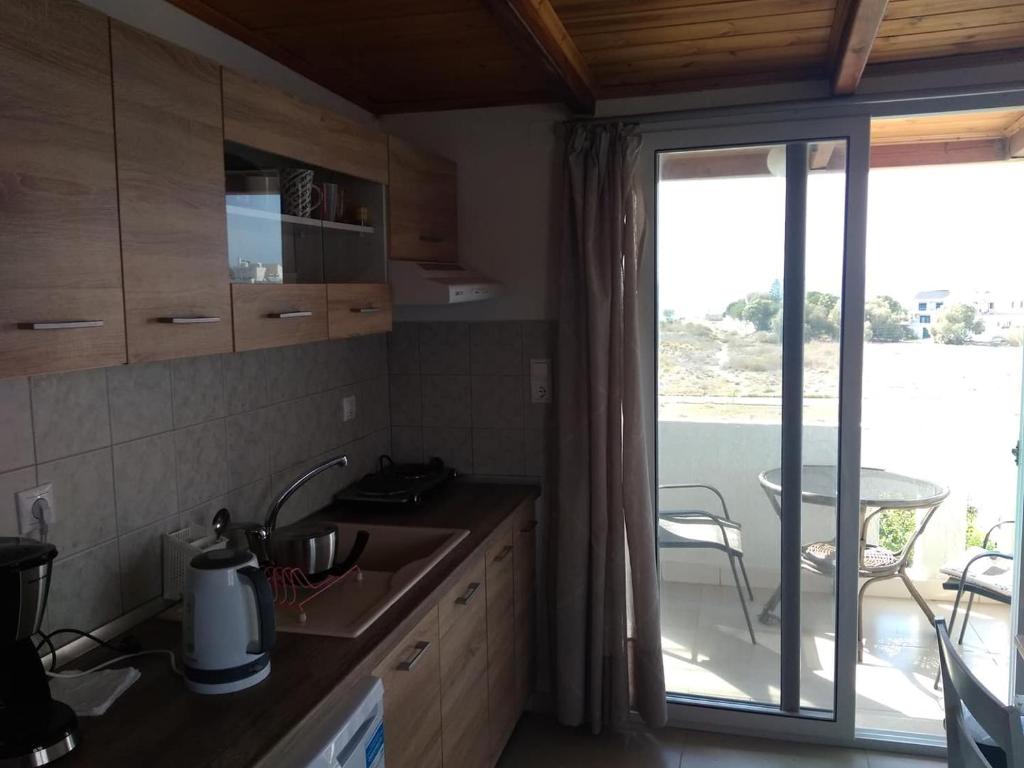 a kitchen with a sink and a sliding glass door at Hotel Aglaia in Kalamaki