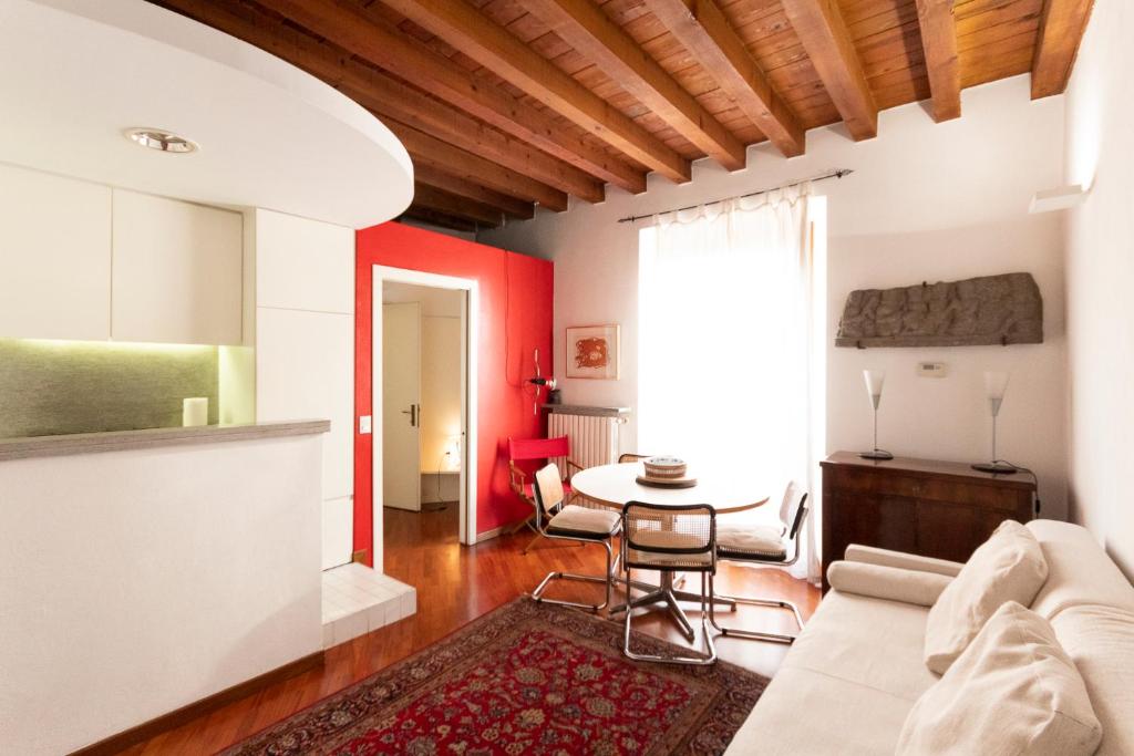 sala de estar con pared de acento rojo y mesa en Brera Anfiteatro Apartment, en Milán