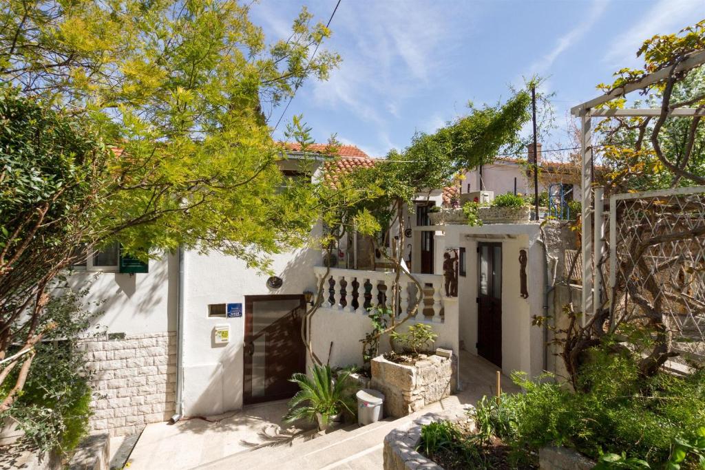 uma casa branca com uma cerca branca e árvores em Apartments Varos em Split