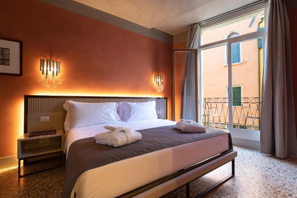 een slaapkamer met een groot bed en een groot raam bij Liassidi Arco in Venetië