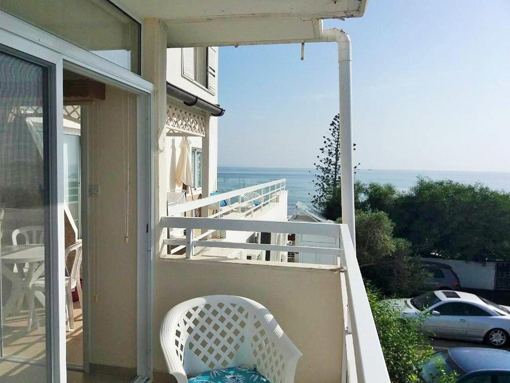 a white chair sitting on the porch of a house at 16 SANDY BEACH in Larnaca