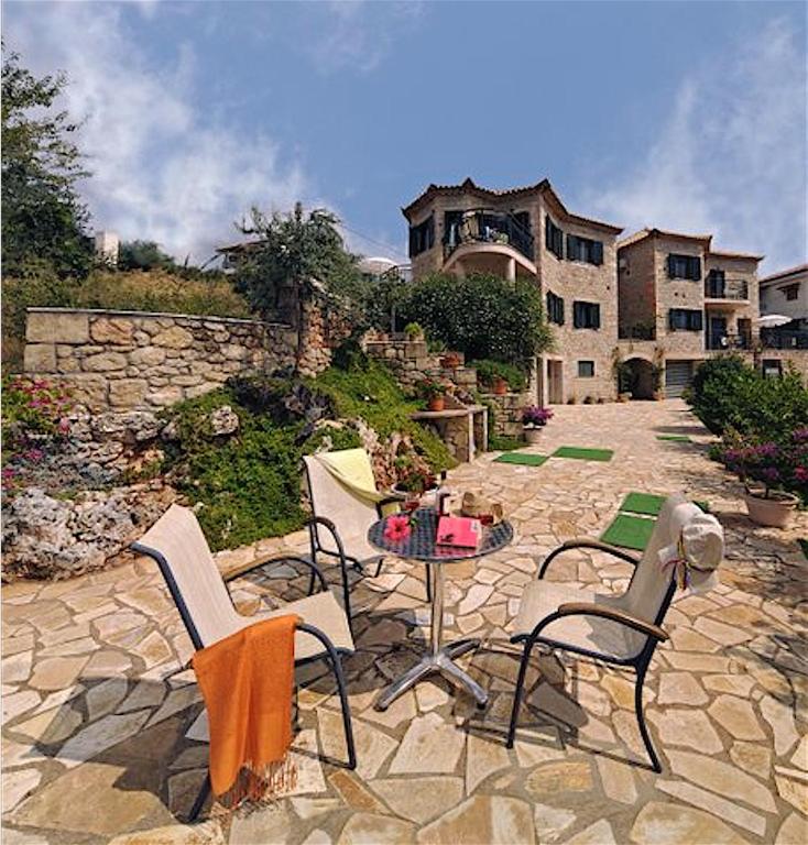 a patio with chairs and a table in front of a building at Kalogria Villas in Stoupa