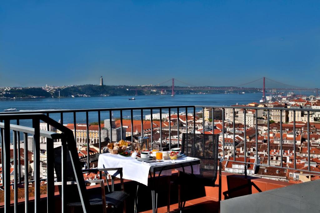 a table on a balcony with a view of a city at Solar Dos Mouros in Lisbon