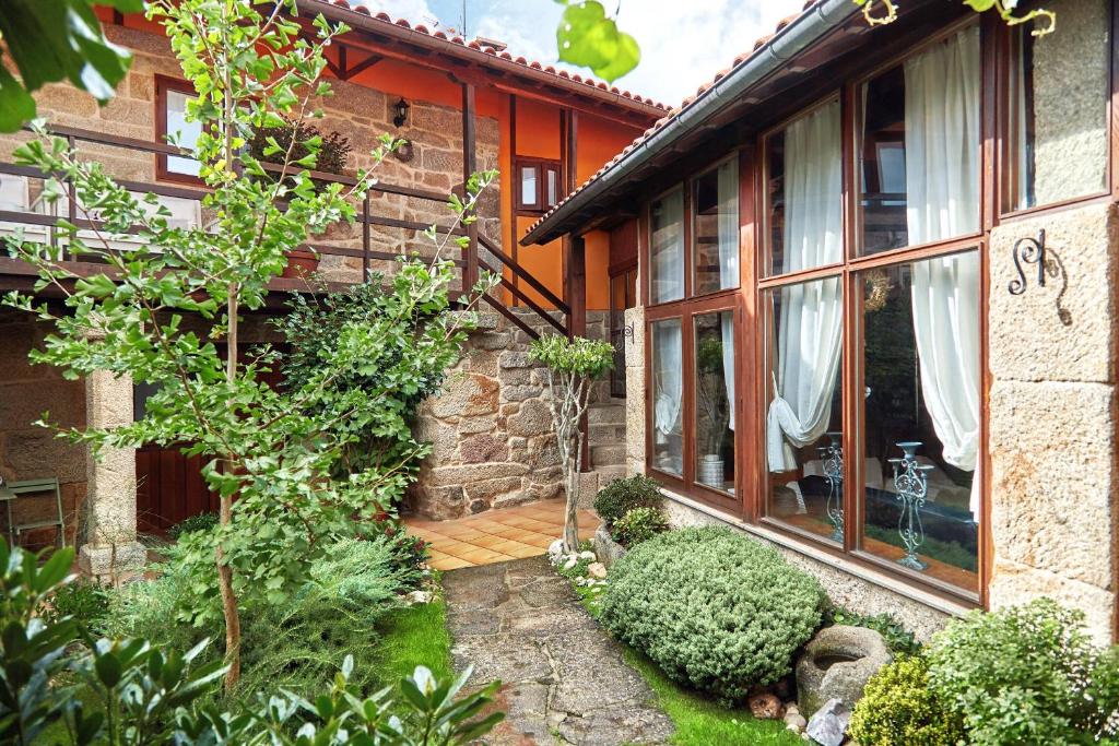une maison en briques avec une terrasse couverte et une cour dans l'établissement Casa Rural Sabariz, à Sabariz