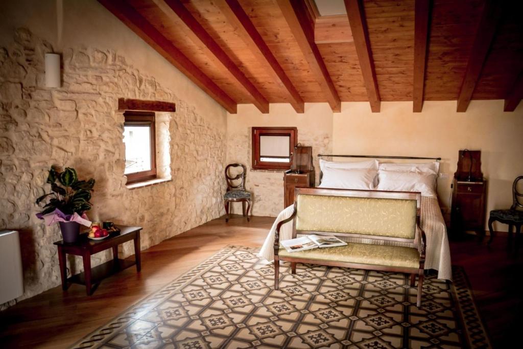 a bedroom with a bed and a stone wall at Agriturismo Valentina Cubi in Fumane