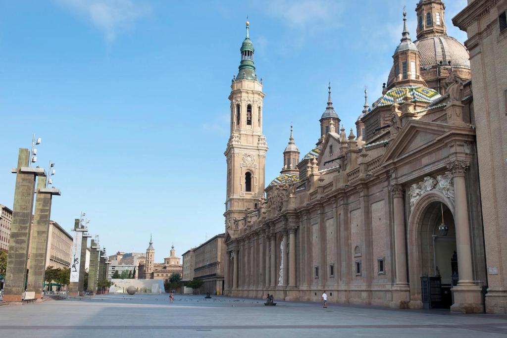 a large building with a clock tower in the background at El Jardín de Verónica in Zaragoza