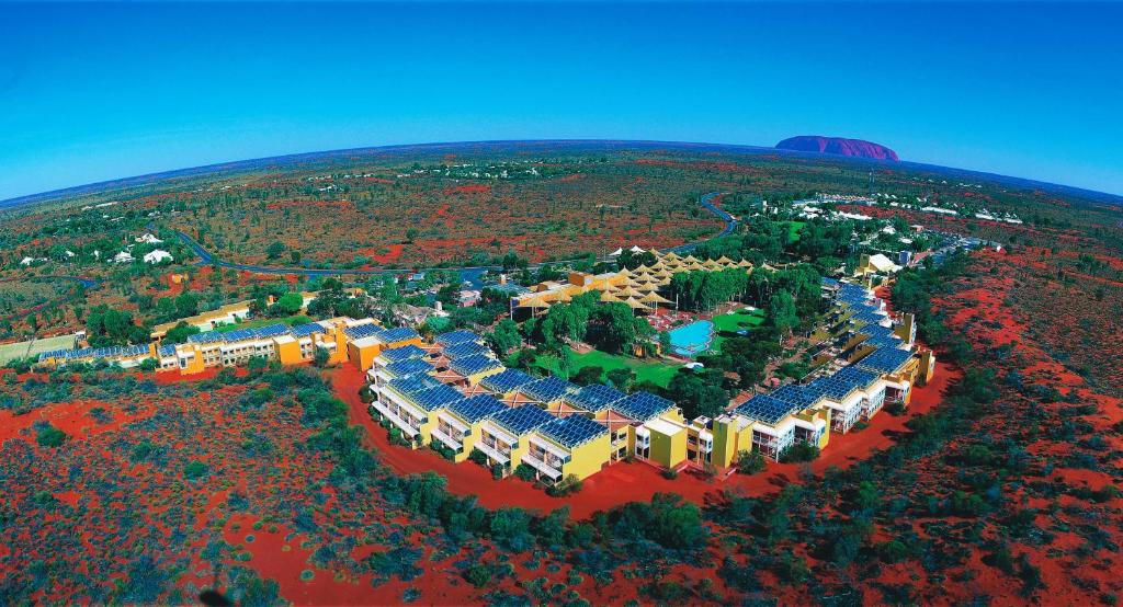 an aerial view of a city with a mountain at Sails in the Desert in Ayers Rock
