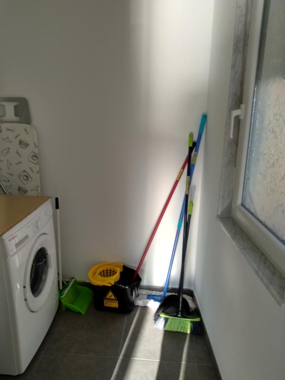a laundry room with a washing machine and mop at Apartamento Camelle in Camelle