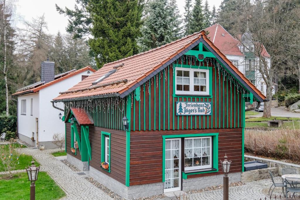 韋尼格羅德的住宿－Ferienhaus "Jägers Ruh"，一座绿色和棕色的小建筑,有房子