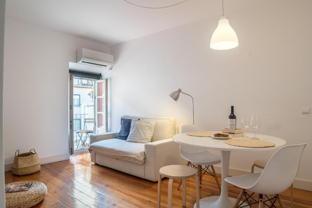 a white living room with a table and a couch at LX 77 in Lisbon