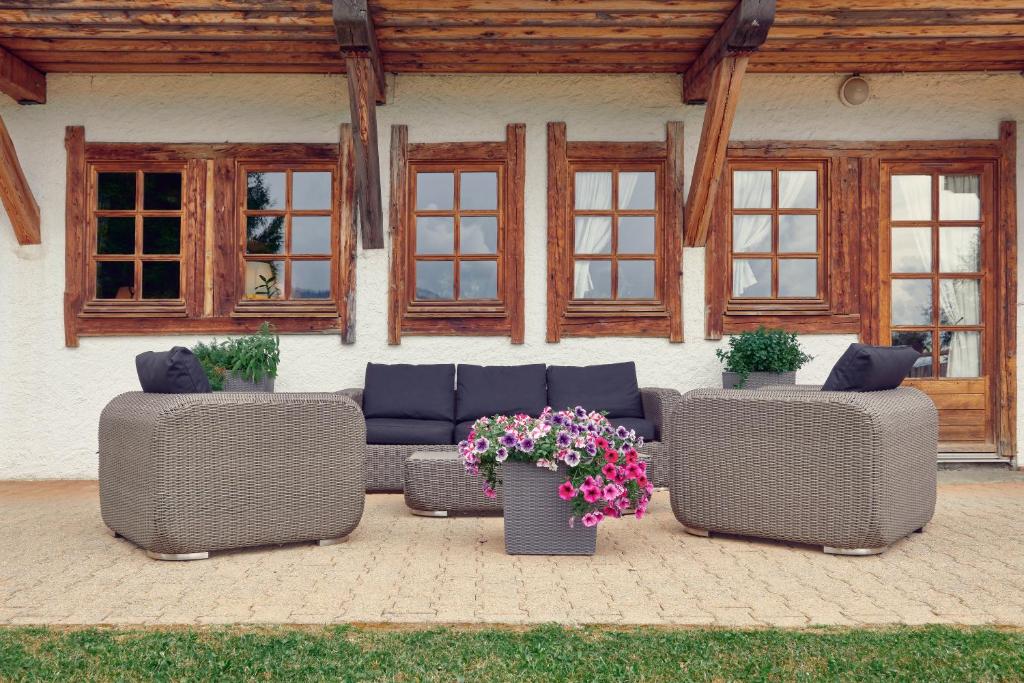 a patio with couches and flowers in front of a building at La Ferme du Golf in Megève