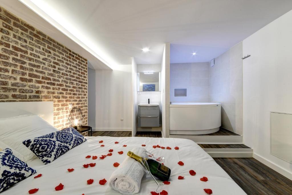 ein Schlafzimmer mit einem Bett mit roten Rosen darauf in der Unterkunft My Toul'House SPA in Toulouse
