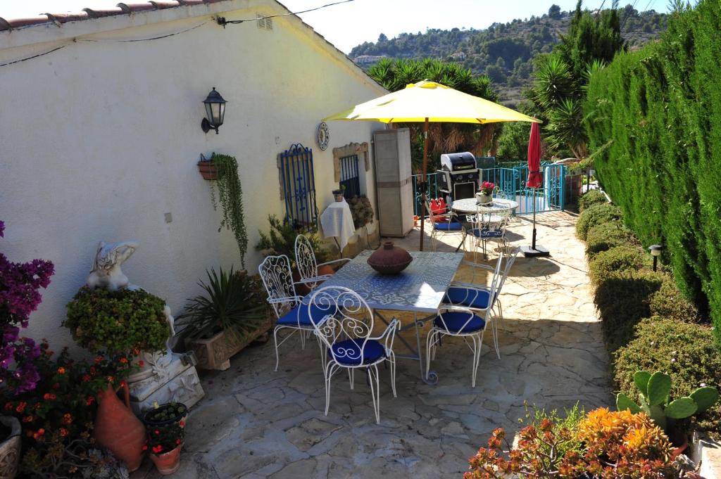 a patio with a table and chairs and an umbrella at EOLE in Benissa