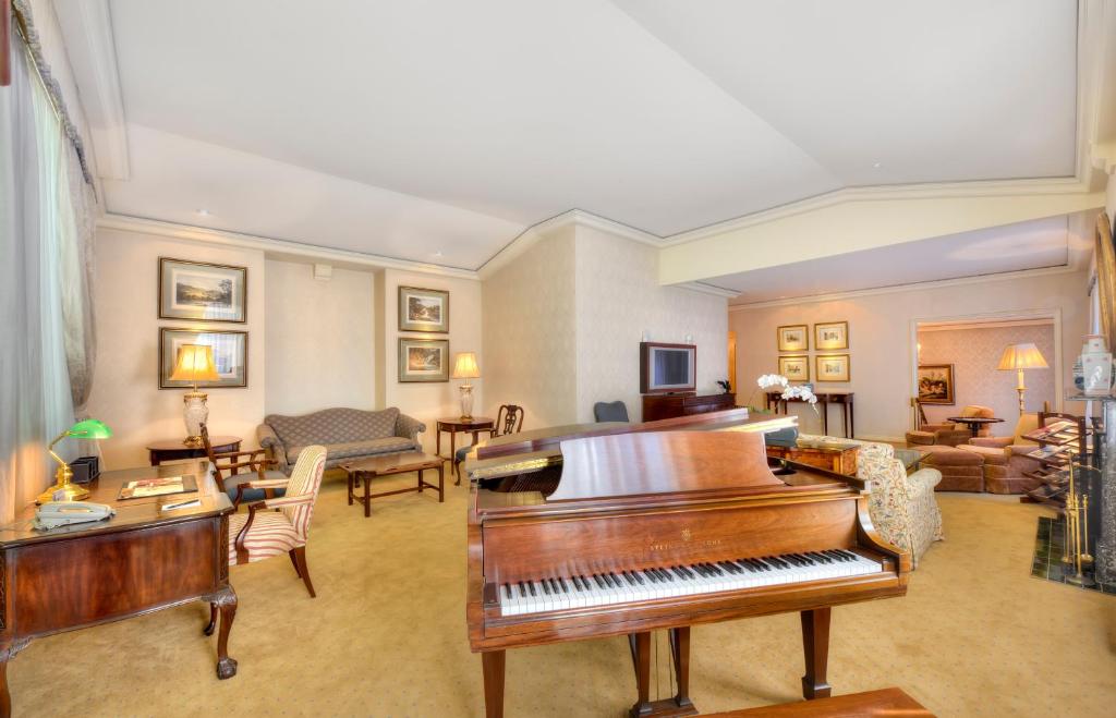 a living room filled with furniture and a piano at Sir Stamford Circular Quay in Sydney
