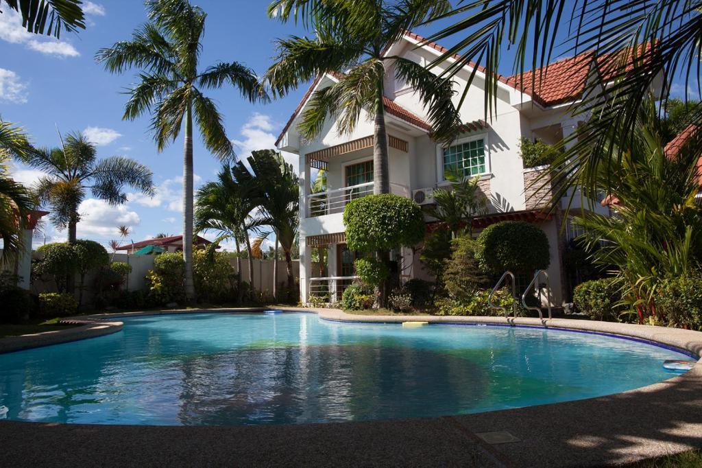 a house with a swimming pool in front of a house at Sir Nico Guesthouse and Resort in Plaridel