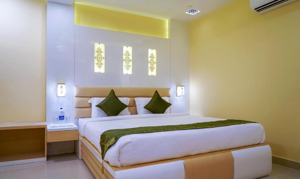 a bedroom with a large bed and two windows at Treebo Trend Oasis Cuttack Puri in Bhubaneshwar