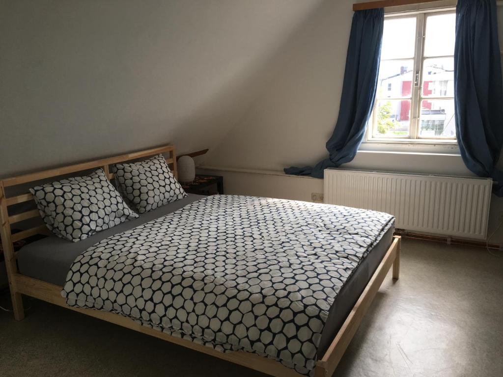 sypialnia z łóżkiem z niebieskimi zasłonami i oknem w obiekcie Apartment ANKA w mieście Bad Ischl