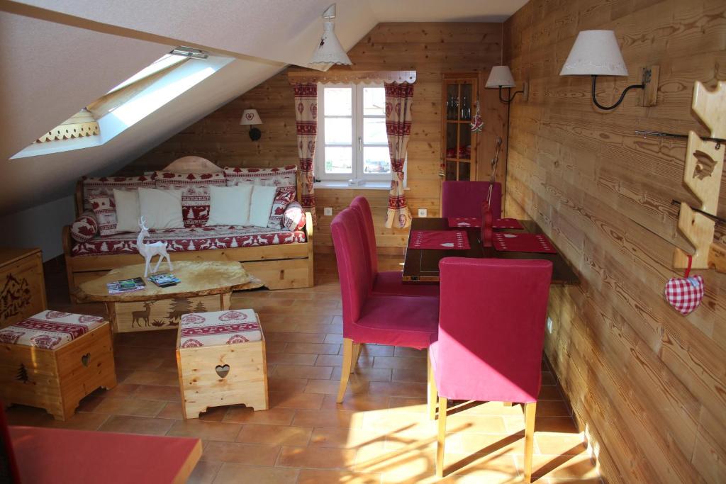 Habitación con mesa, sillas y cama en Le Refuge Géromois en Gérardmer