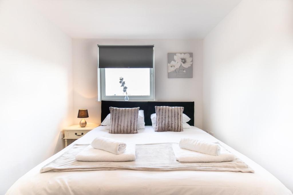 a bedroom with a large white bed with two pillows at 2-bedroom apartment Mill Court, Harlow in Harlow