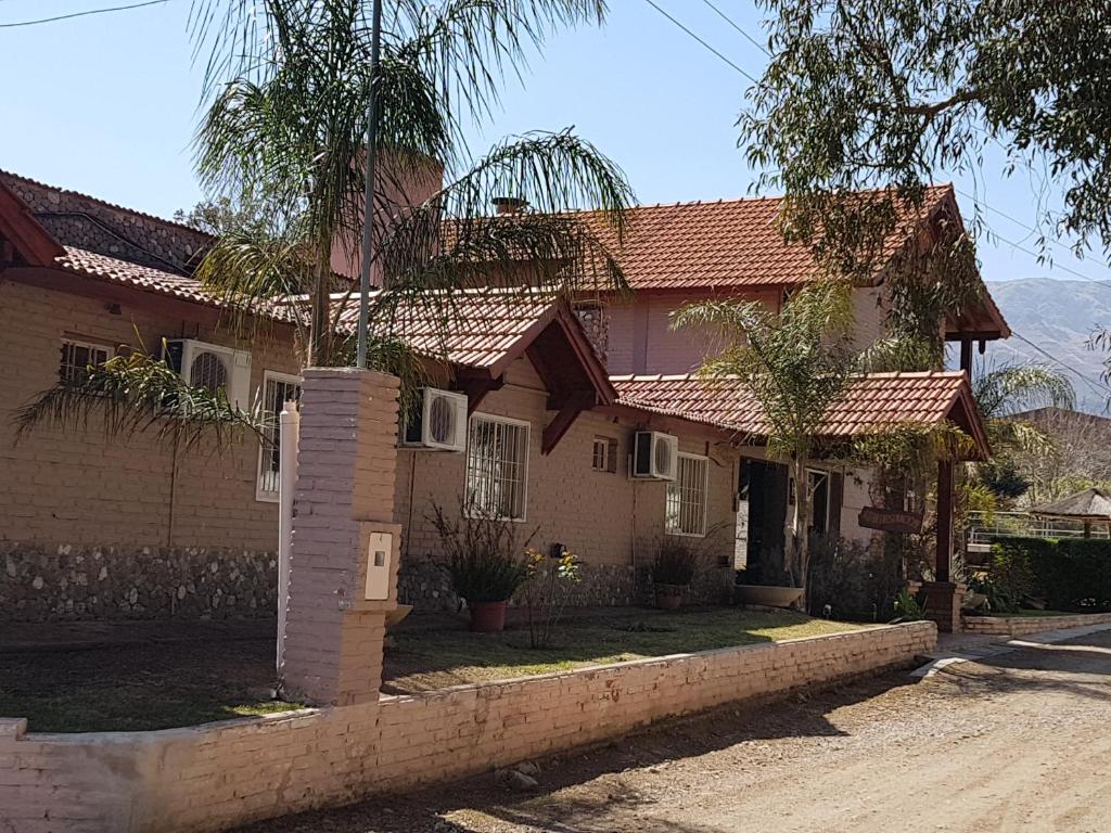 una casa con una palmera delante de ella en Apart Hotel Piscu Yaco en Merlo